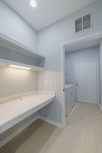 A white door is in a room with white walls and a window.